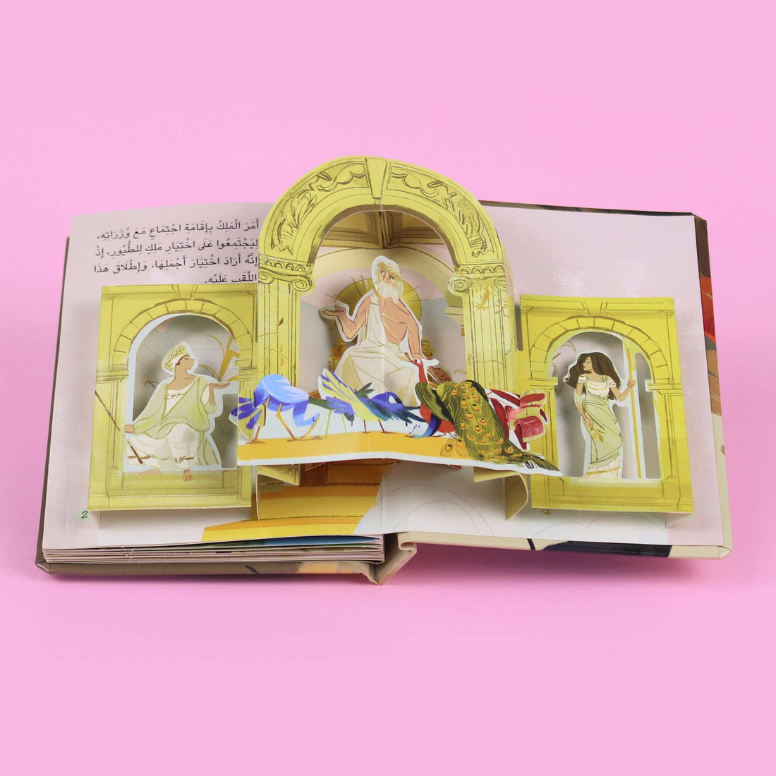 غلاف كتاب ثلاثي الأبعاد "الغراب وريشه الجميل" يظهر طيور الغابة والغراب يرتدي ريشًا ملوّنًا بطريقة جذابة.